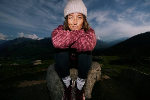 Close-up of a person in hiking boots scrambling over a&nbsp;rock