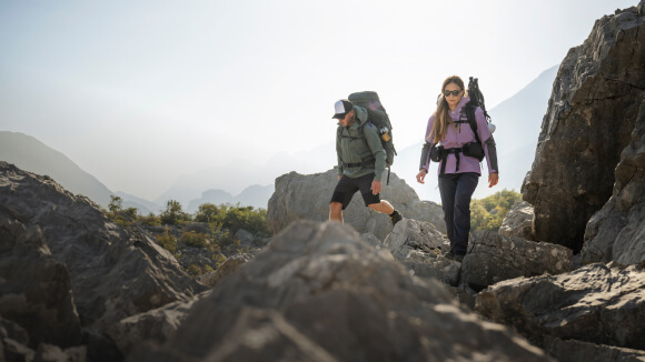 Dos personas en un camino frente a un impresionante paisaje de montaña