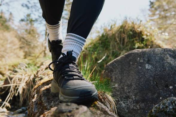 Two hikers from behind with packs on their backs, walking across a wooden&nbsp;bridge
