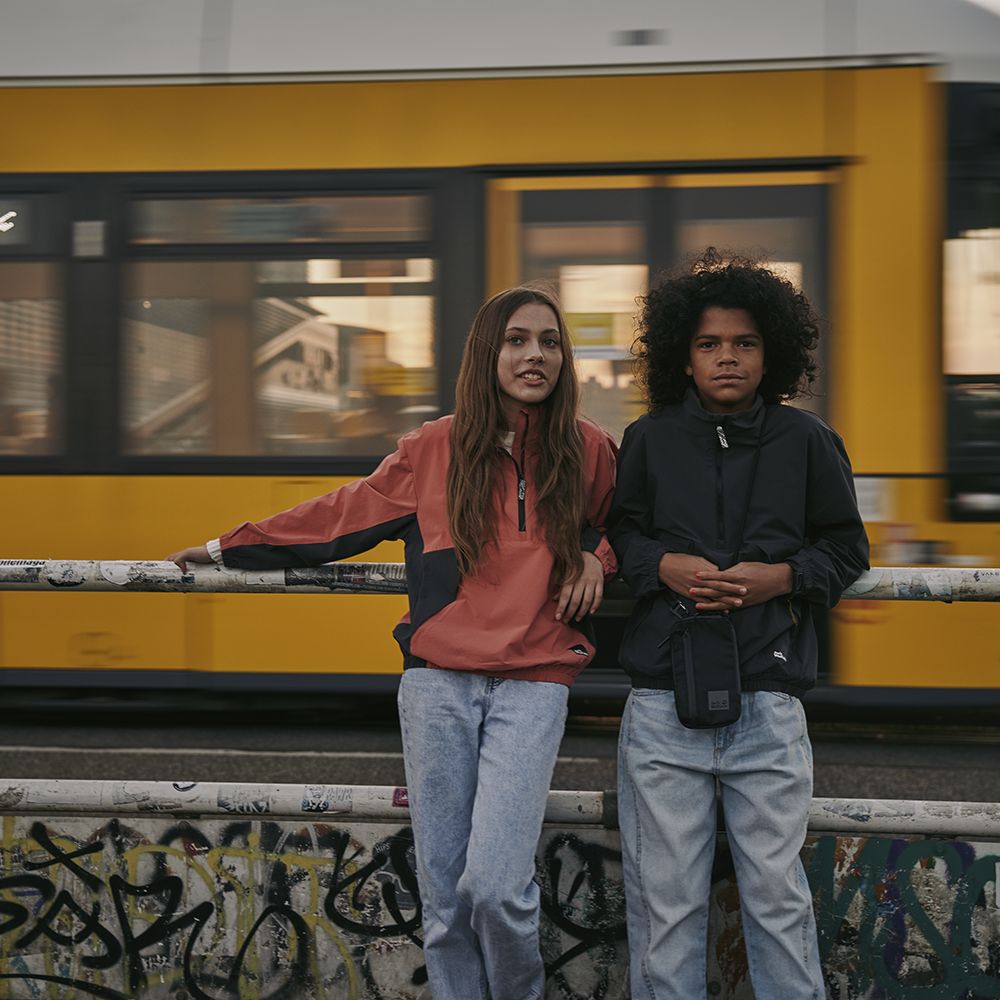 Girl and boy in front of a moving tram