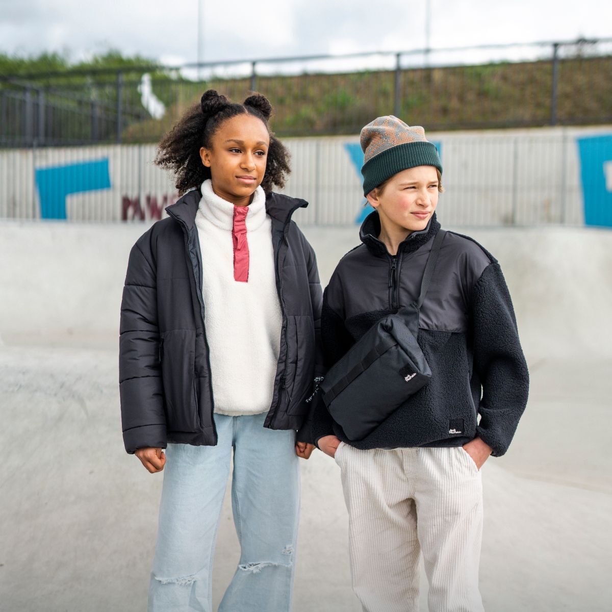 Girl and boy on skateboarding court