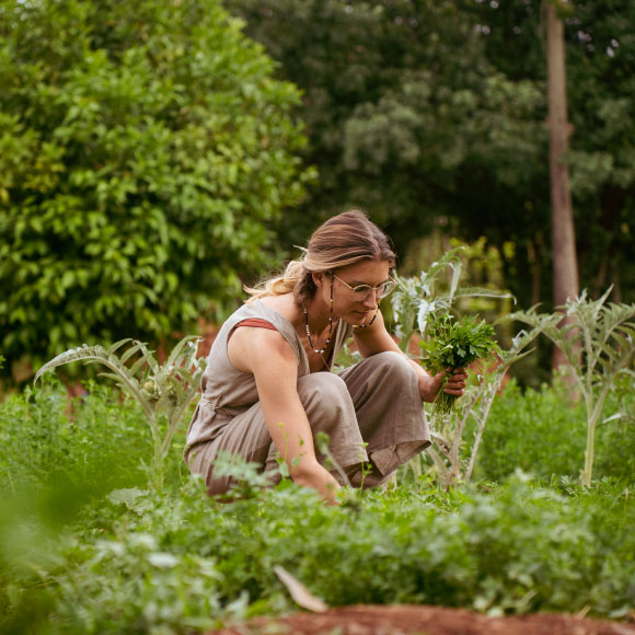 Margarita picking herbs in a garden