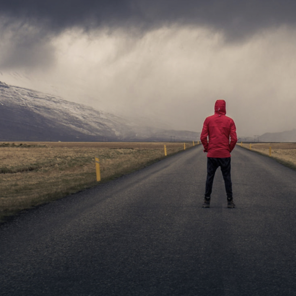 Justin, photographed from behind, on a mountain road