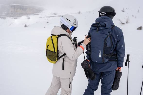 Woman and man in ski clothing in a snowy mountain&nbsp;landscape